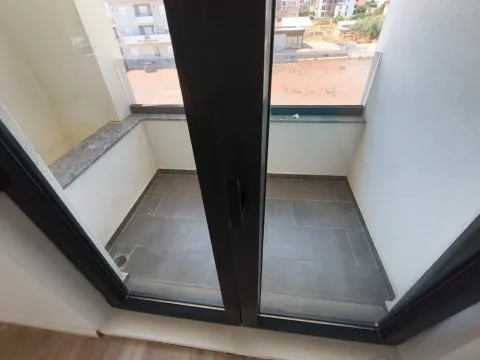 Manji popločani balkon sa staklenom ogradom i pogledom na okolinu. - image 9