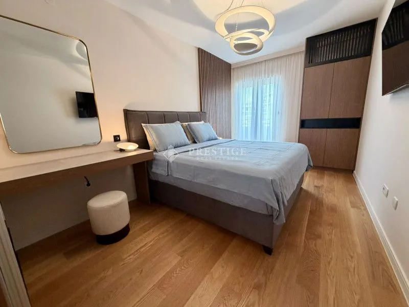 Moderna spavaća soba sa bračnim krevetom, garderoberom i ogledalom.