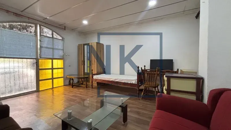 Living room with a sofa set, bed, and wooden furniture.