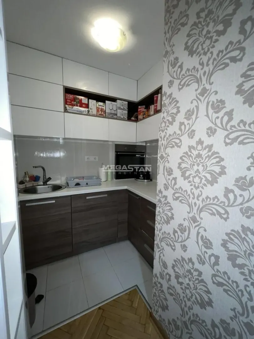 Smaller kitchen with white upper and dark lower cabinets.