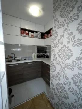 Smaller kitchen with white upper and dark lower cabinets. - image 6