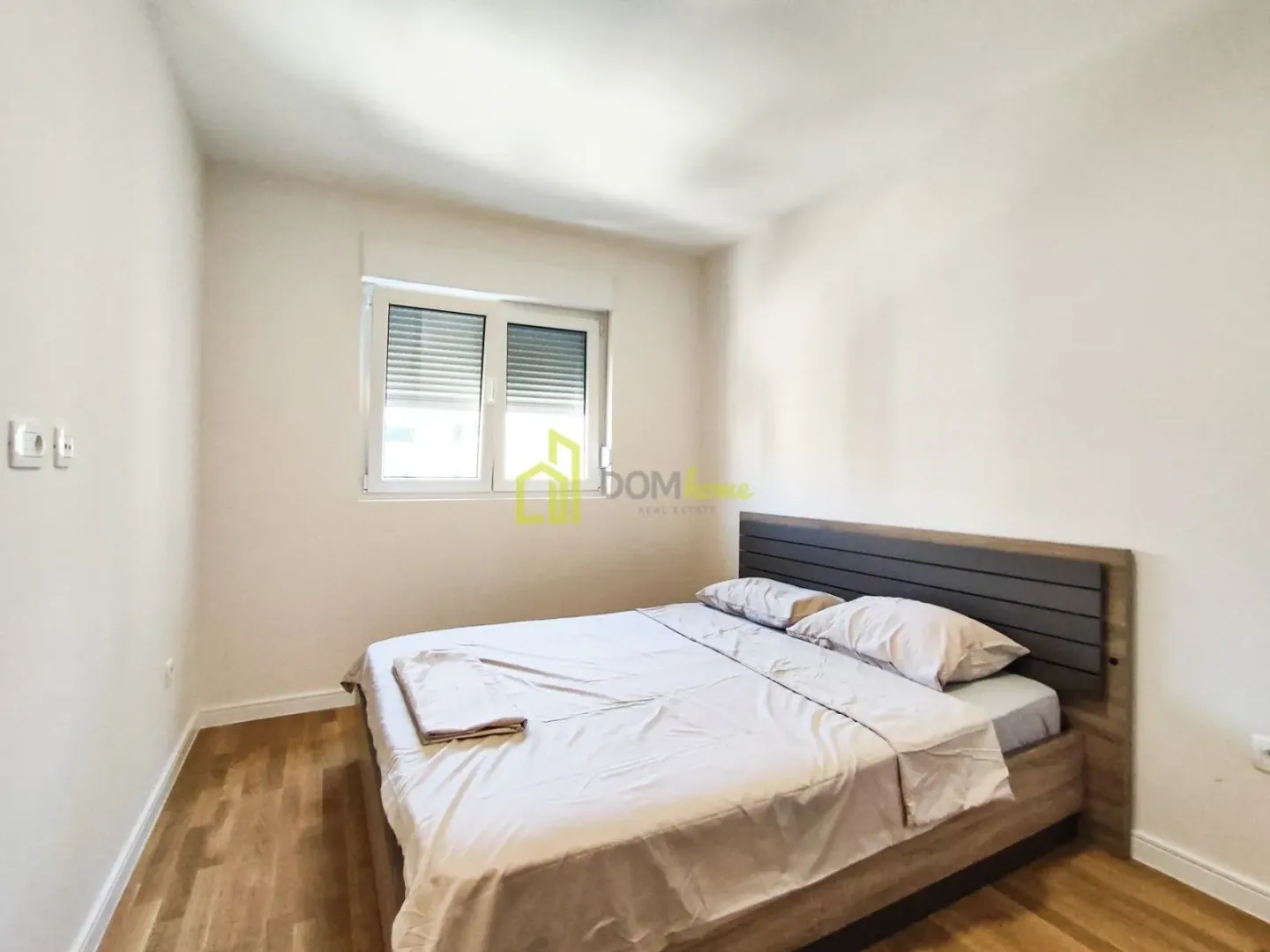 Furnished bedroom with a double bed and a window.