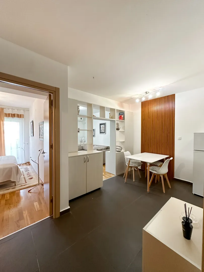 Living room with dining area and a view into the bedroom.