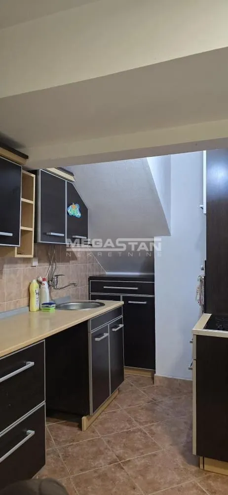 Small kitchen with dark cabinetry and a sink.