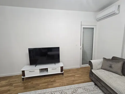 Living room with a sofa, TV, and air conditioning unit. - image 14