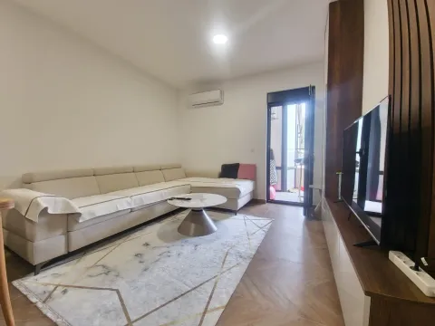 Living room with a sectional sofa, coffee table, television, and access to the terrace. - image 7