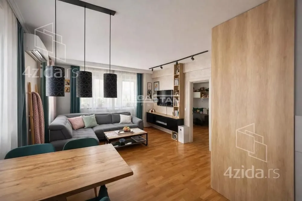 Living room with a sofa, dining table, and modern lighting.