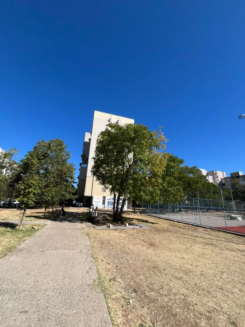 View of the building, courtyard, and sports field with a walkway.