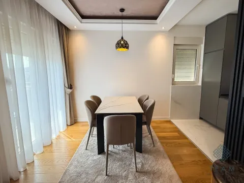 Dining area with a table, chairs, and modern pendant light. - image 4