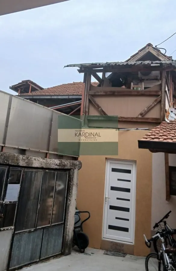 Pogled na spoljašnjost kuće sa dvorišnim ulazom.