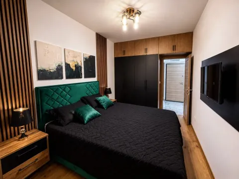 Modern bedroom with a double bed, wooden wall panels, and built-in wardrobes. - image 4