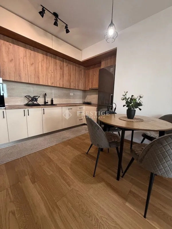 Modern kitchen with wooden elements and a dining table.