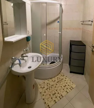 Small bathroom with a washbasin, shower cabin, and cabinet. - image 3