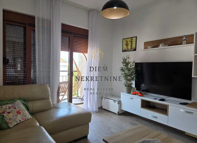 Living room with sofa, TV and access to the terrace.