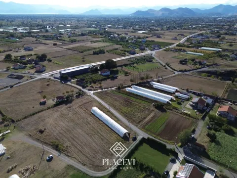 Pogled iz vazduha na zemljište i okolno naselje sa planinama u pozadini. - image 3