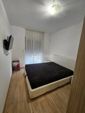 Spavaća soba sa bračnim krevetom i televizorom na zidu. - image 5