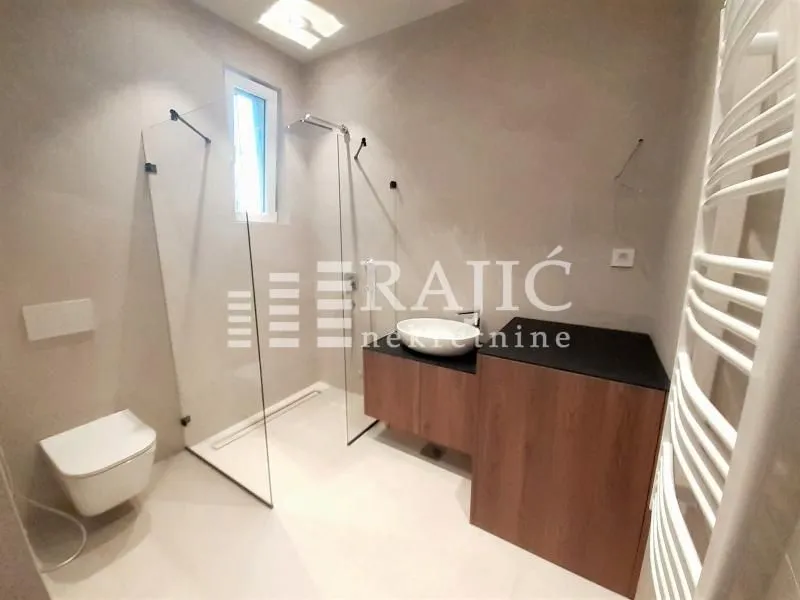 Modern bathroom with walk-in shower, vanity, and fitted sanitary ware.