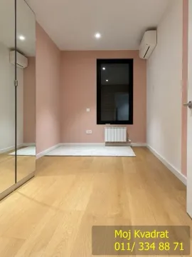 Empty bedroom with a pink accent wall, wooden flooring, and a mirrored built-in wardrobe. - image 10
