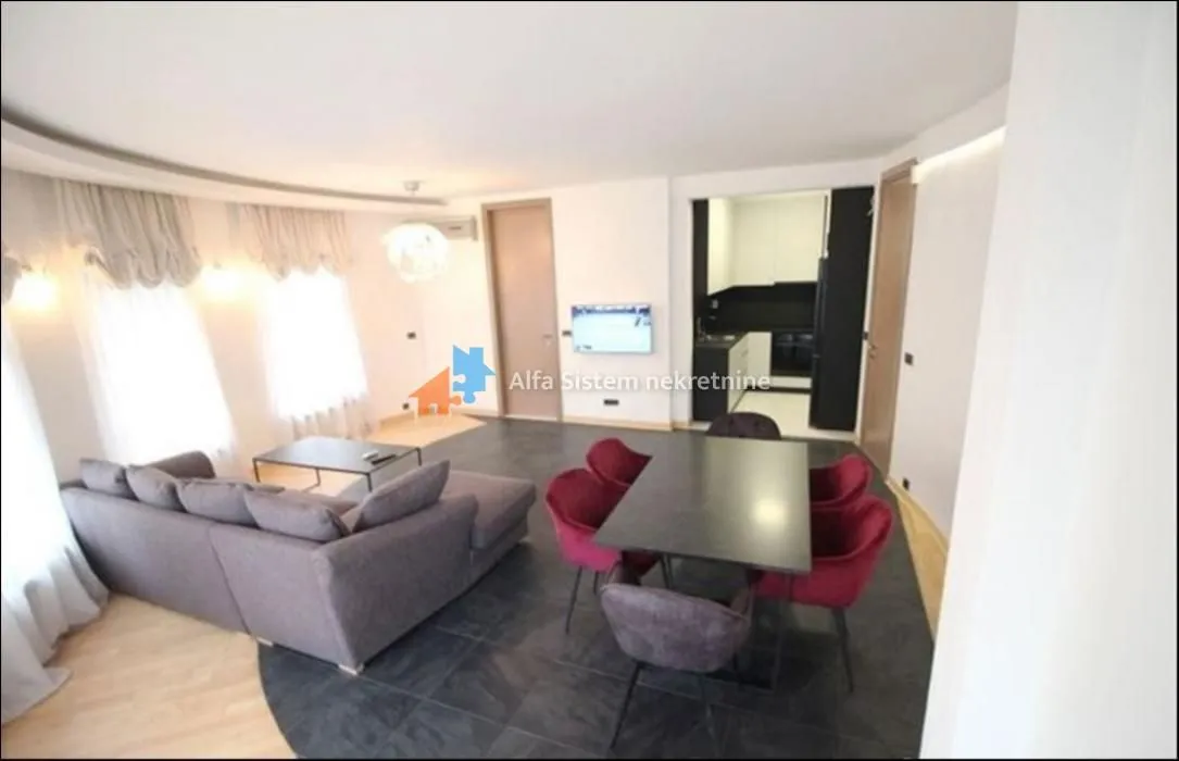 Spacious living room with a sofa set, dining table, and a view of the kitchen.