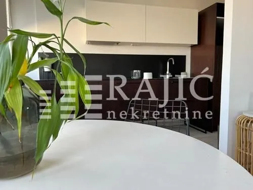 Pogled na moderno opremljenu kuhinju sa belim elementima.