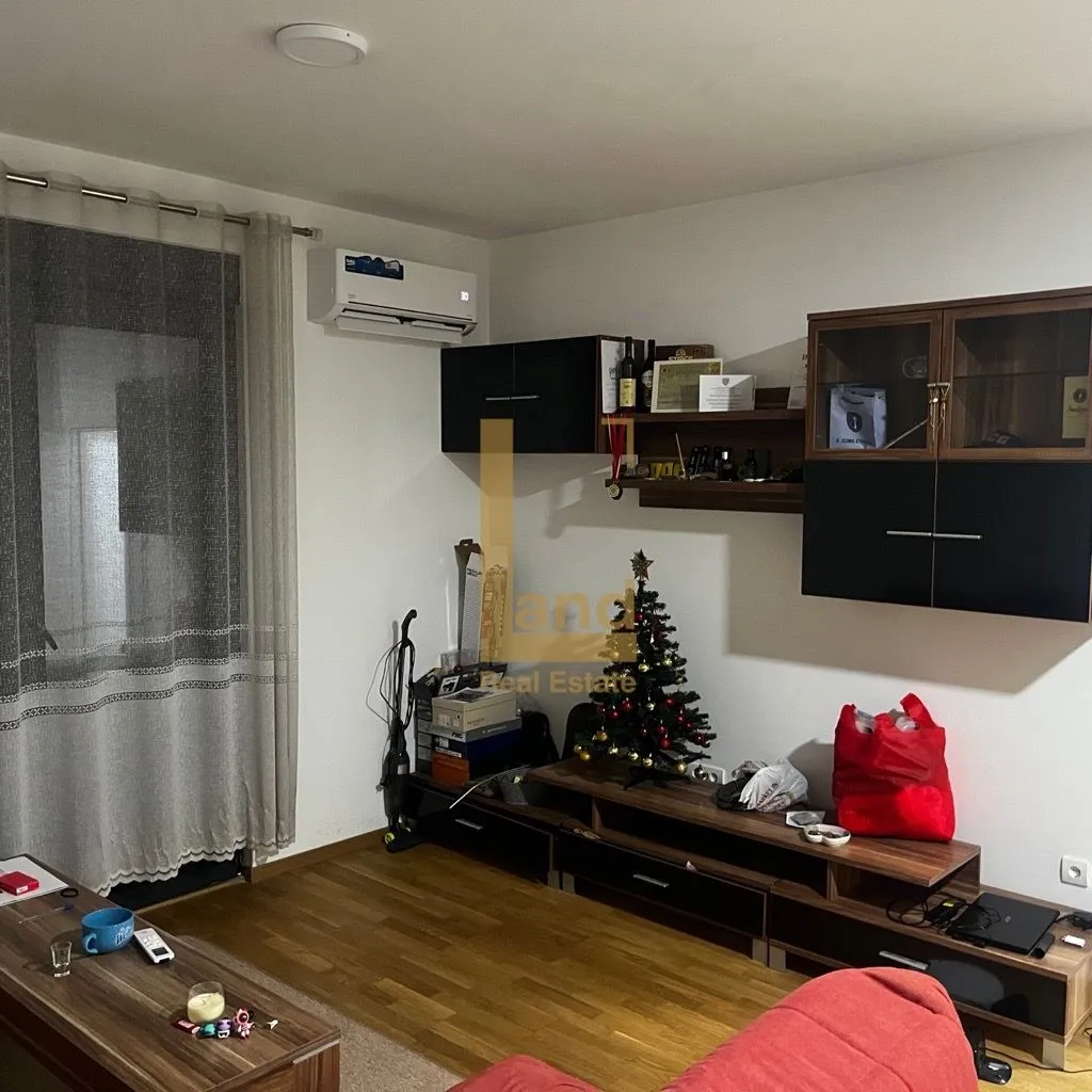 Dnevna soba sa namještajem i jelkom.