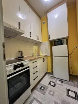 Manja opremljena kuhinja sa belim elementima i šporetom. - image 8
