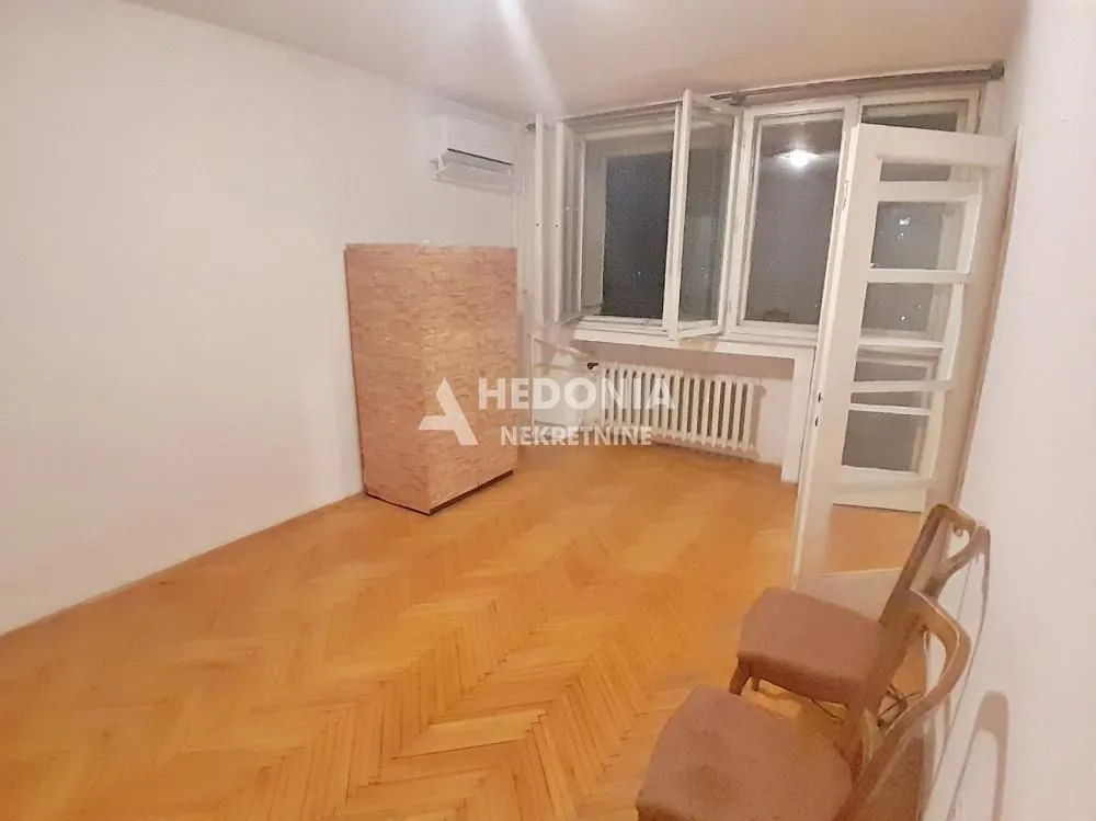 Empty room with parquet flooring, a window, and an air conditioning unit.