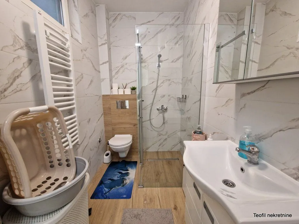 Savremeno opremljeno kupatilo sa tuš kabinom, umivaonikom i wc šoljom.