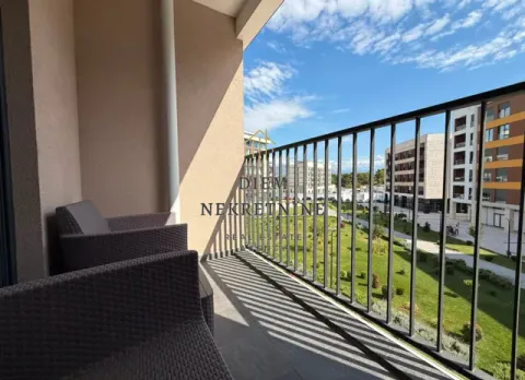 Small covered balcony with seating furniture and a view of the building courtyard. - image 18