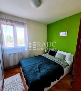 Furnished bedroom with a double bed and a green accent wall. - image 3