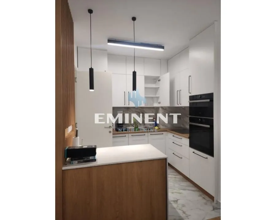 Modern white kitchen with wooden details and built-in appliances.
