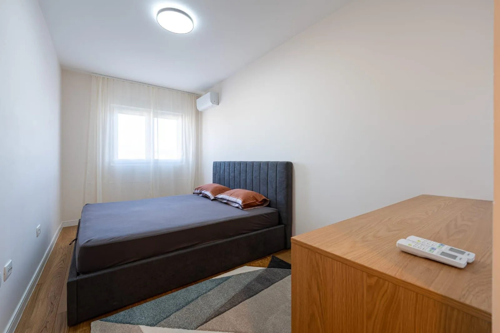 Bedroom with a double bed and a wooden chest of drawers.