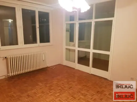Prazna soba sa parketom, radijatorom i staklenim pregradnim zidom. - image 2