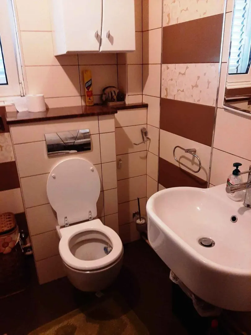 Malo kupatilo sa toaletnom šoljom i lavaboom.
