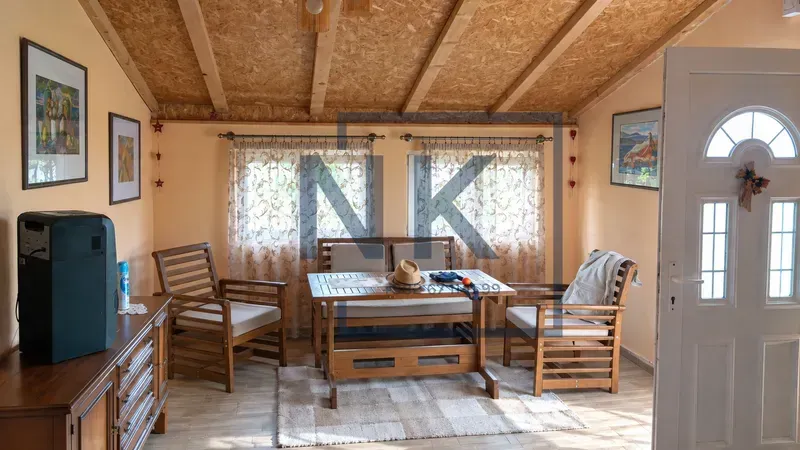 Living room with wooden furniture and a sloped ceiling.
