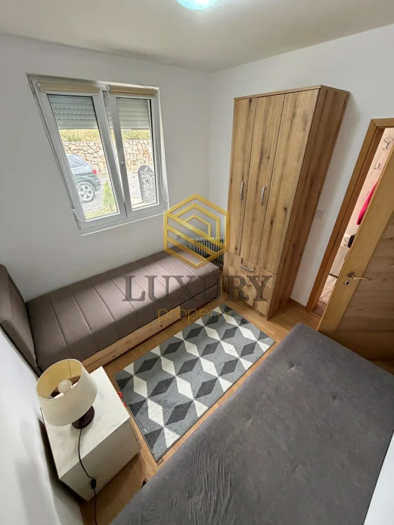 Small bedroom with two beds, a wardrobe, and a window.