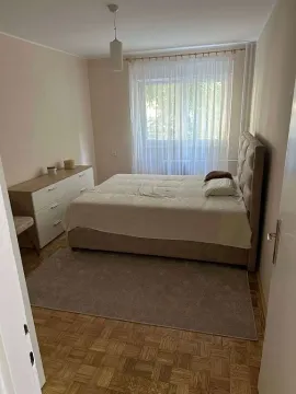 Nameštena spavaća soba sa bračnim krevetom i komodom. - image 7