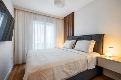 Modern bedroom with a double bed, wall-mounted TV, and bedside table. - image 8