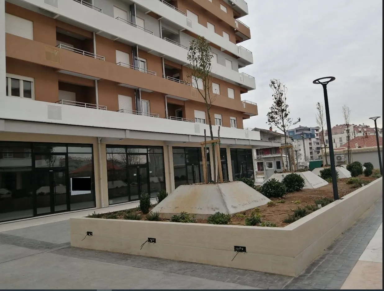Exterior of a modern residential building with a landscaped yard in front.