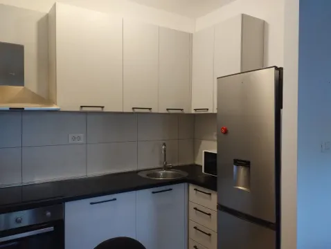 Modern kitchen with white cabinets and a refrigerator. - image 8