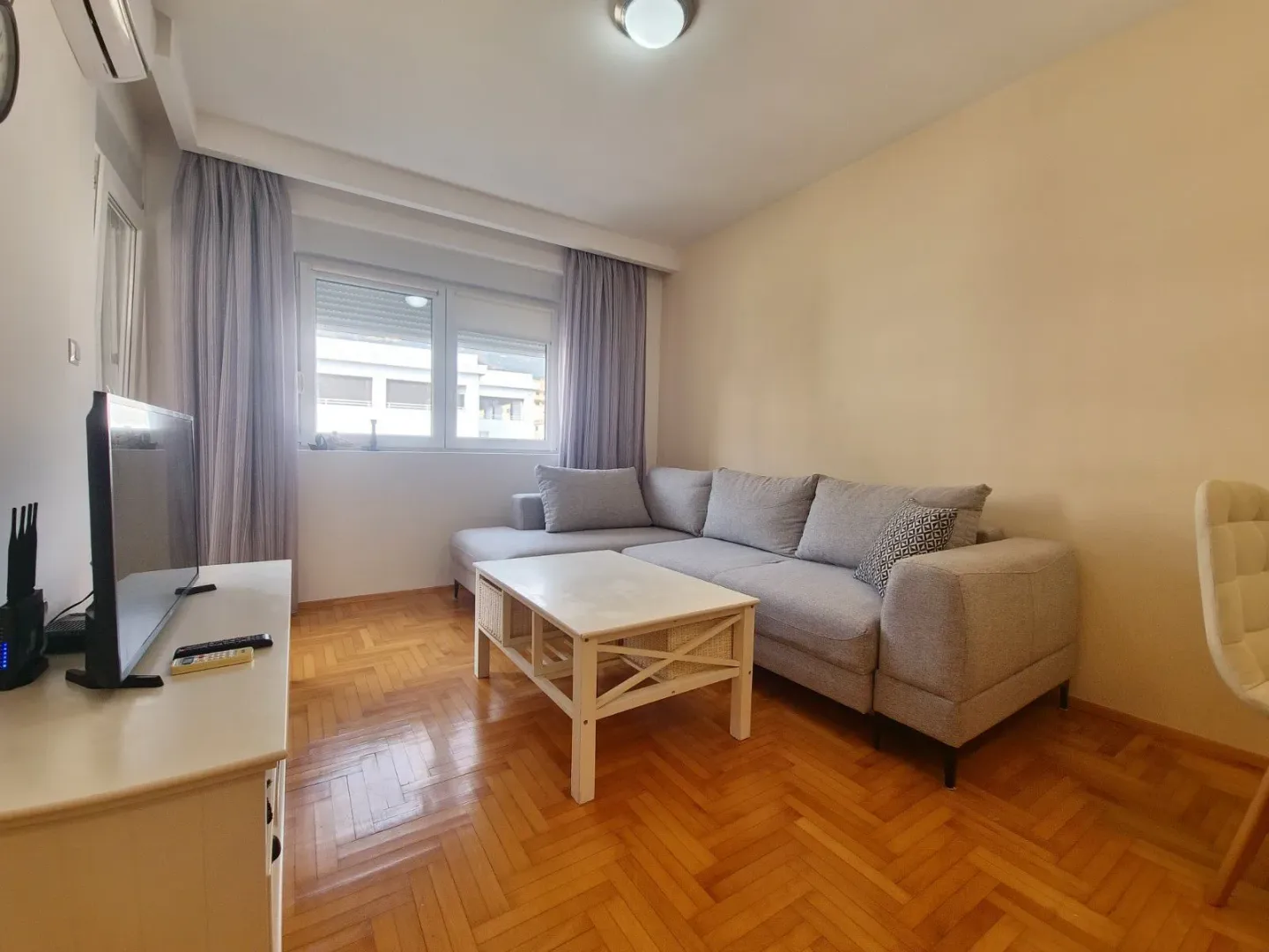 Living room with a corner sofa, coffee table and TV.