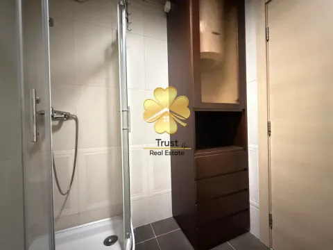 Modernly equipped bathroom with a shower cabin and a dark cabinet. - image 20