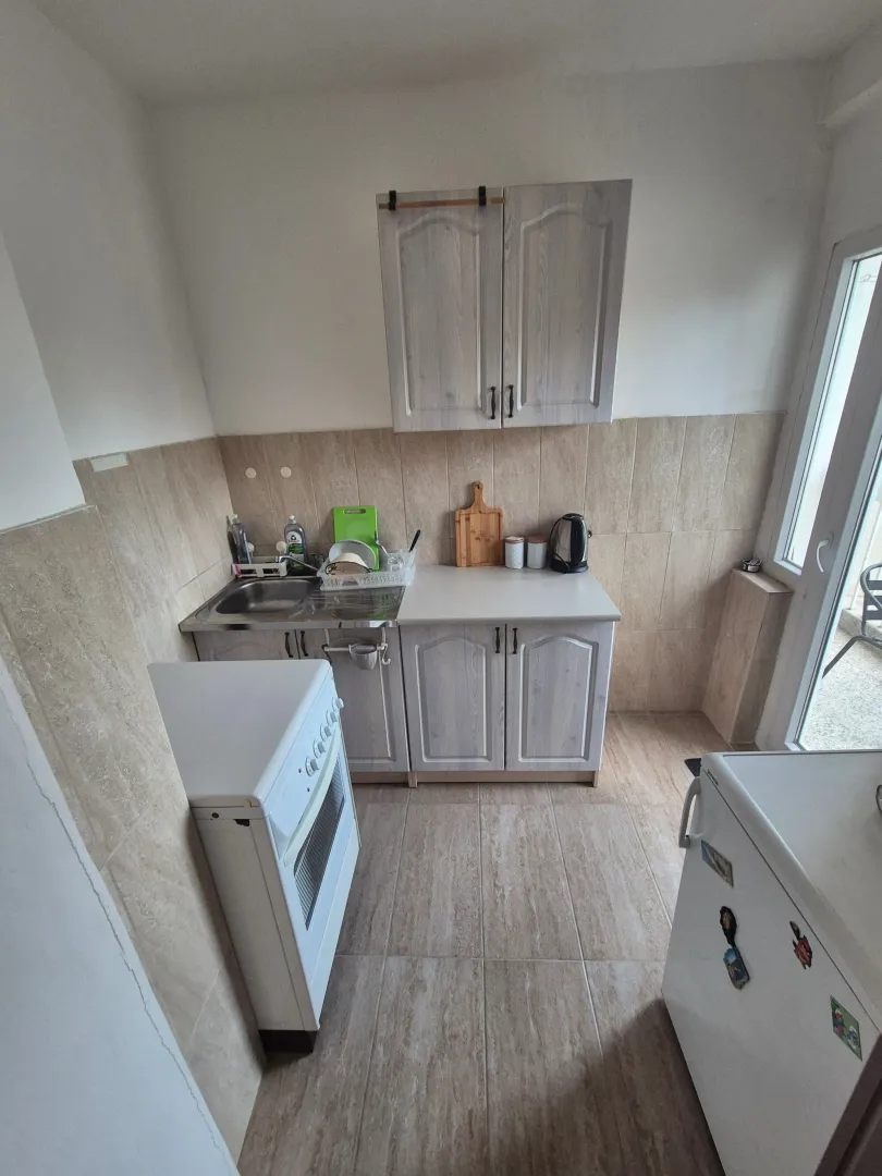 Small kitchen with light-colored cabinets and a stove.