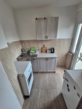 Small kitchen with light-colored cabinets and a stove. - image 4