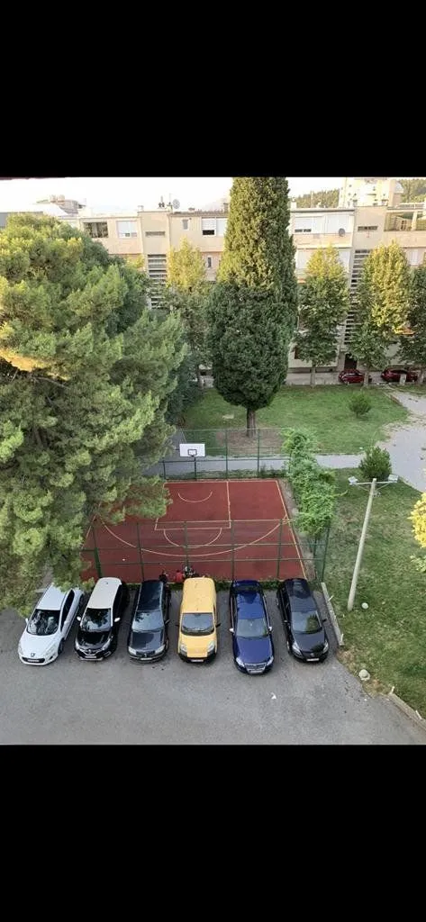 View from the window overlooking the parking lot and a basketball court.