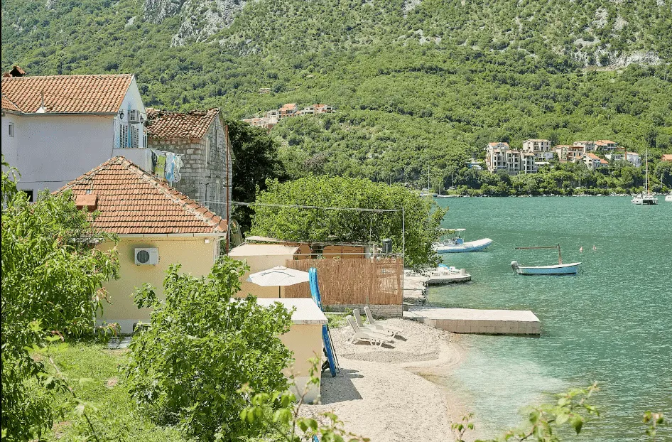 Pogled na kuće sa dvorištem i plažom pored mora.