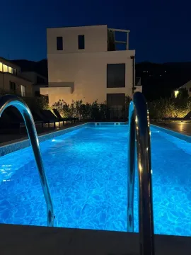 Noćni pogled na osvijetljeni bazen ispred moderne kuće. - image 10