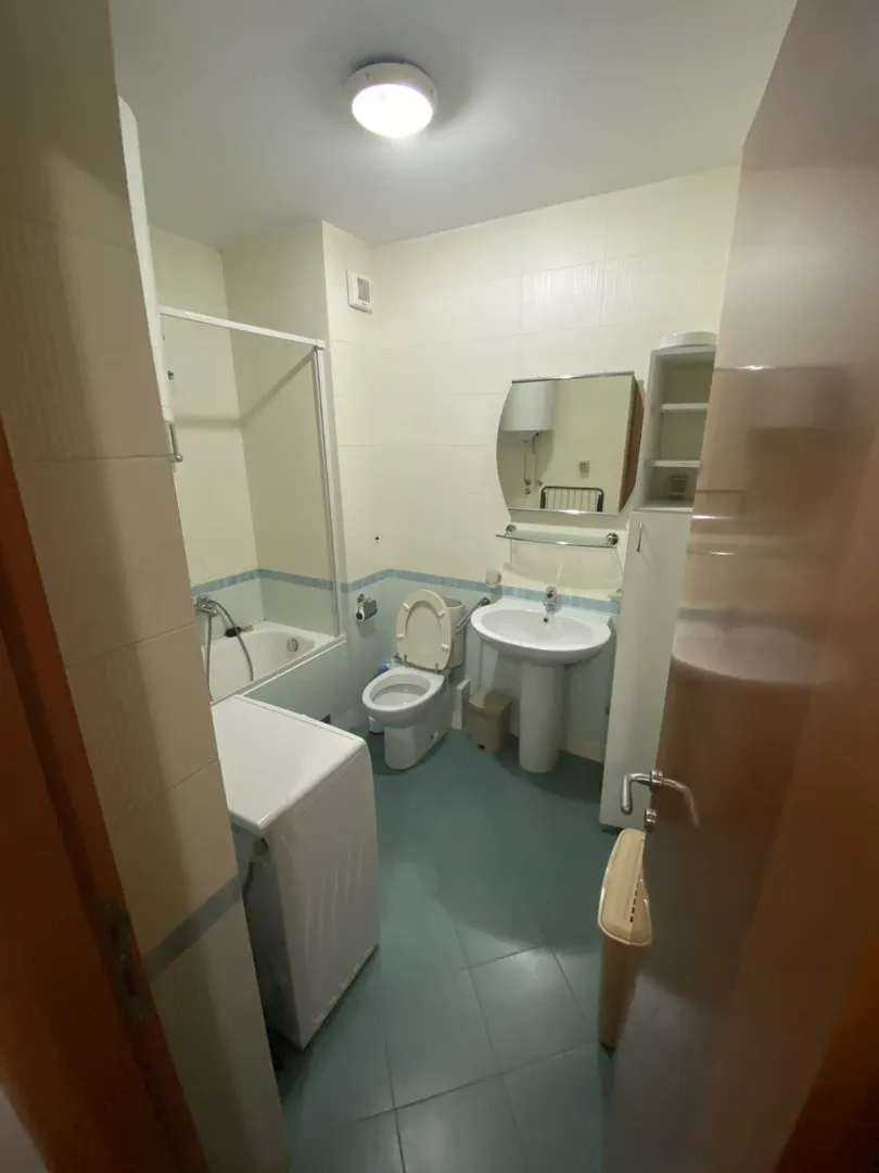 Bathroom with a bathtub, sink, and washing machine.