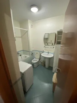 Bathroom with a bathtub, sink, and washing machine. - image 11