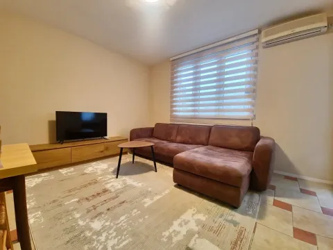 Living room with a sectional sofa, TV, and air conditioner. - image 6